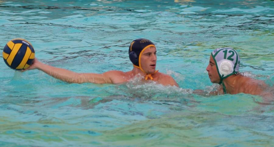 Senior Anthony Dracic holds the ball away from Granada Hill’s No.12 during the semi-final game at Birmingham Community Charter High School’s swimming pool on Nov. 16.  The Patriots defeated the Granada High Landers 20-6 and continued onward to finals against Pacific Palisades High School on Nov. 19.