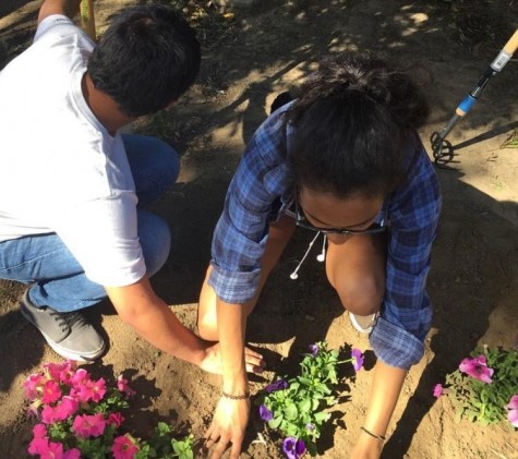 Alumni Ludyn Vasquez and Imani Brown plant flowers during last year's Sparkle Saturday event.