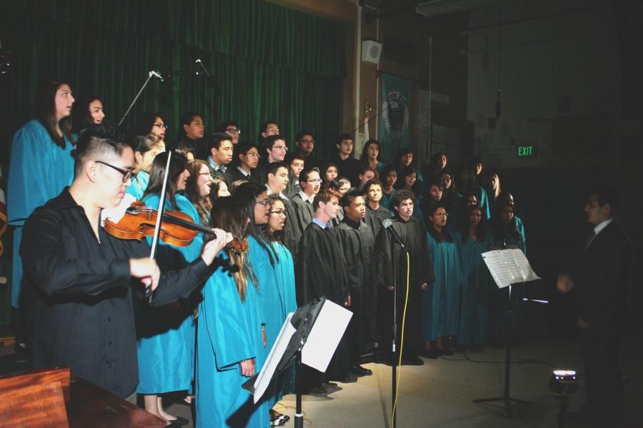 Daniel Pearl Magnet High School’s choir sings three musical pieces beginning with “Shalom Alecheim” with Daniel Lee (left) on the violin and Gor Mkrtchian (right) conducting. The next two pieces include “Shir l’Shalom” and “Next to Me,” which featured soloists. Photo by Jake Dobbs.
