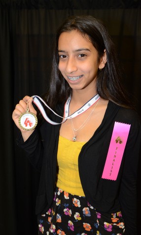 Junior Amanda Arst displays her finalist medal at the state History Day competition. Arst will head to the  national competition in Maryland in June. Photo courtesy Artie Arst.