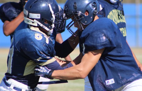 Junior Stanley Cea, on the right, clashes head to head with a teammate during a varsity football practice in preparation for a game versus Newbury Park Aug. 28. Photo by Jordan Timsit