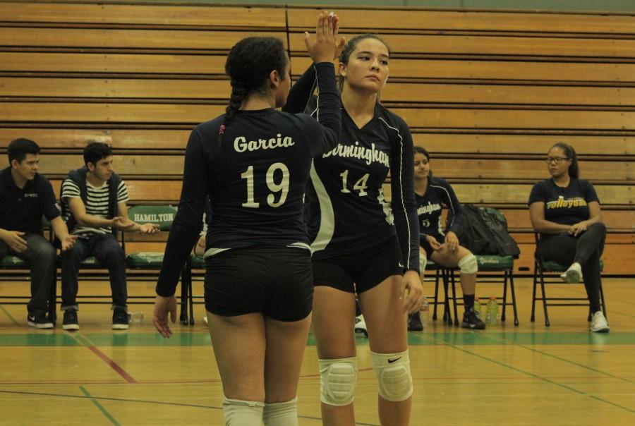 Varsity player Michal Francisco high fives a teammate after the Lady Patriots make a good play in the playoffs. Photo by Jessica Mallari.