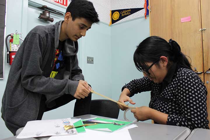 Junior David Diaz and senior Vanessa Fano cut duct tape to make braids and use them as arm tassels for Diaz’s outfit. In order to compensate for not having as much time to work together on weekends, they work in classrooms during nutrition and lunch.