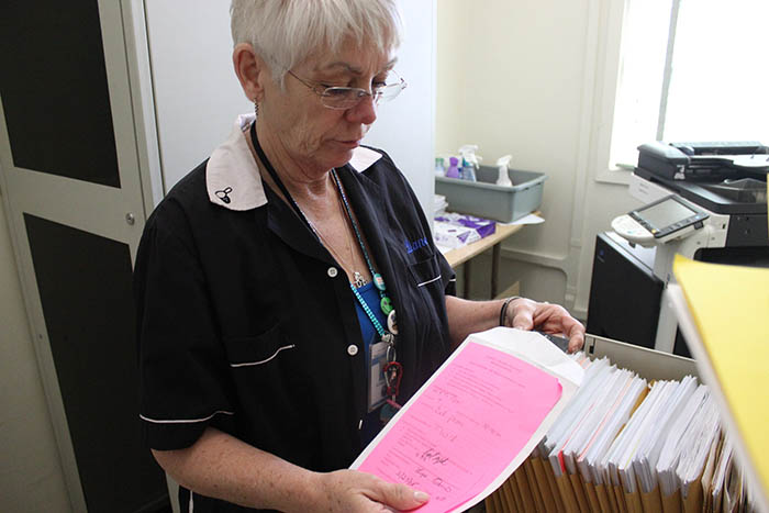 School Administrative Assistant Diane Seiger looks at envelopes that contain confiscated cell phones. Phones taken when used during school hours are locked away and a parent or gaurdian must come to pick them up.