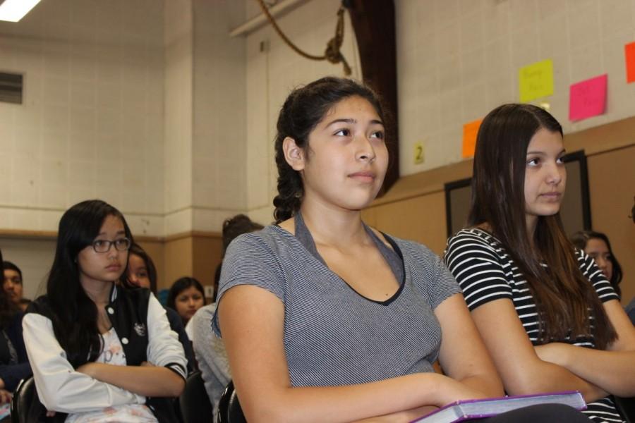 Freshmen Camille Acevedo and Xena McLean  listen closely to Principal Smith during Tuesdays assembly to welcome each class to the new school year. 