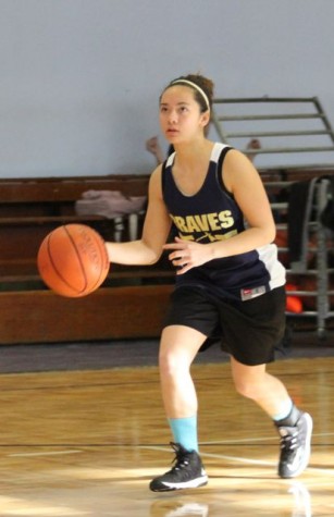 Junior Erica Mallari dribbles down the court eyes on the basket ready to make a shot. 