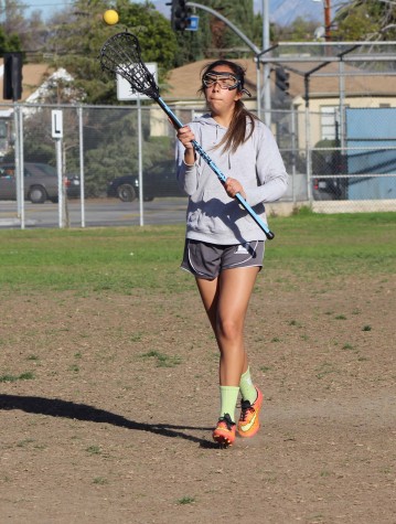 Junior April Serrano holds her stick up ready to catch the ball on the run at Birmingham Community Charter High School. The CIF championship is back on for the Lady Patriots.