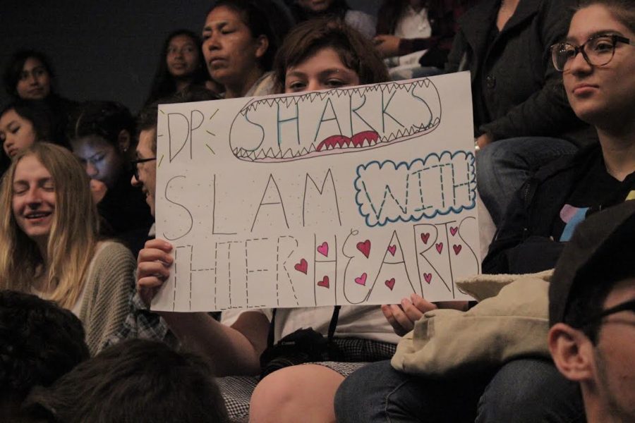 Freshman Anais Delafuente holds a sign cheering on members of the DPMHS Get Lit team. 