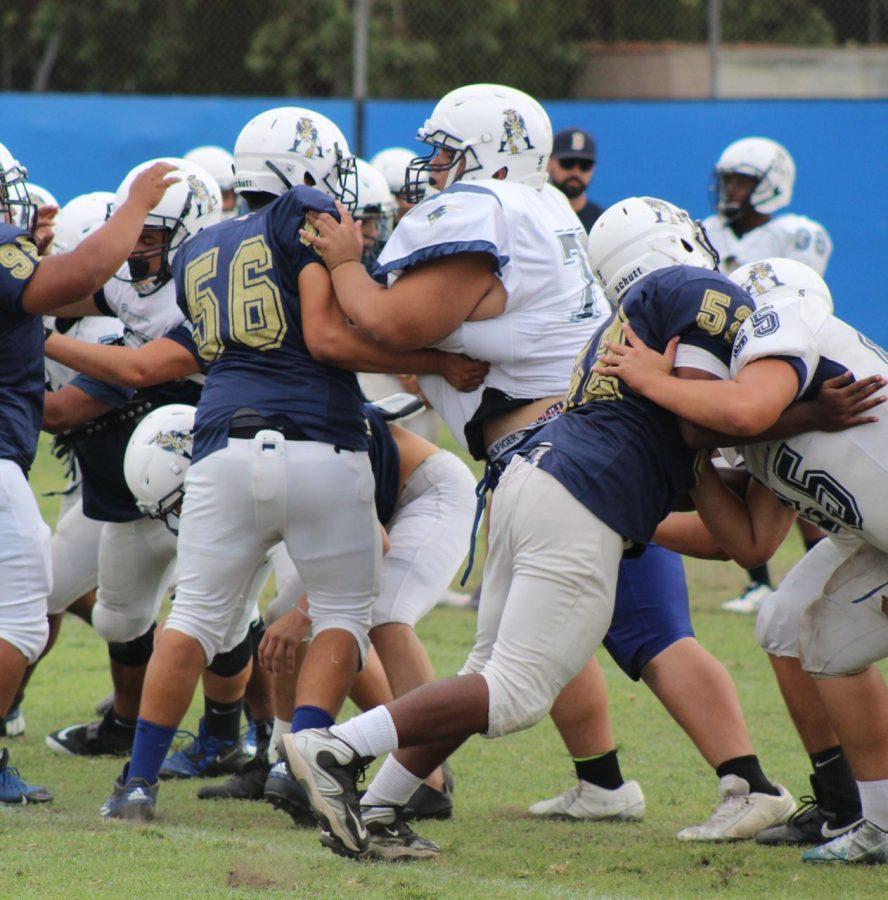 Junior Dean Khazanov tackles fellow teammates  during a practice drill. He has been playing football since his freshman year. 