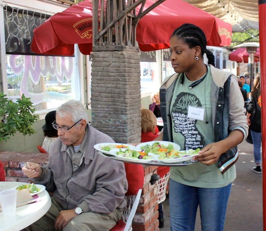 Interact Club President Junior Jade Ajileye clears trays during the Annual Thanksgiving Senior Luncheon on Nov. 24. 