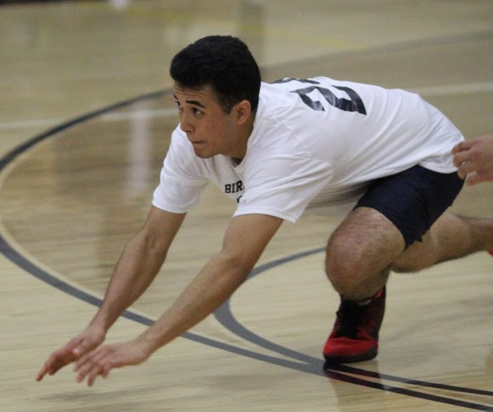 Senior Raul Serrano dives for the volleyball during practice.