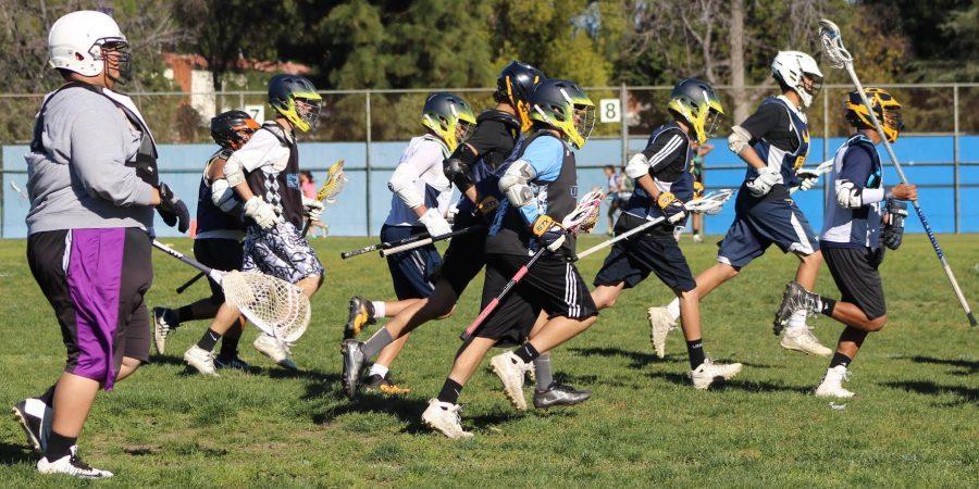 Junior Dean Khazanov runs with the lacrosse team across the field during practice at Birmingham Community Charter High School.