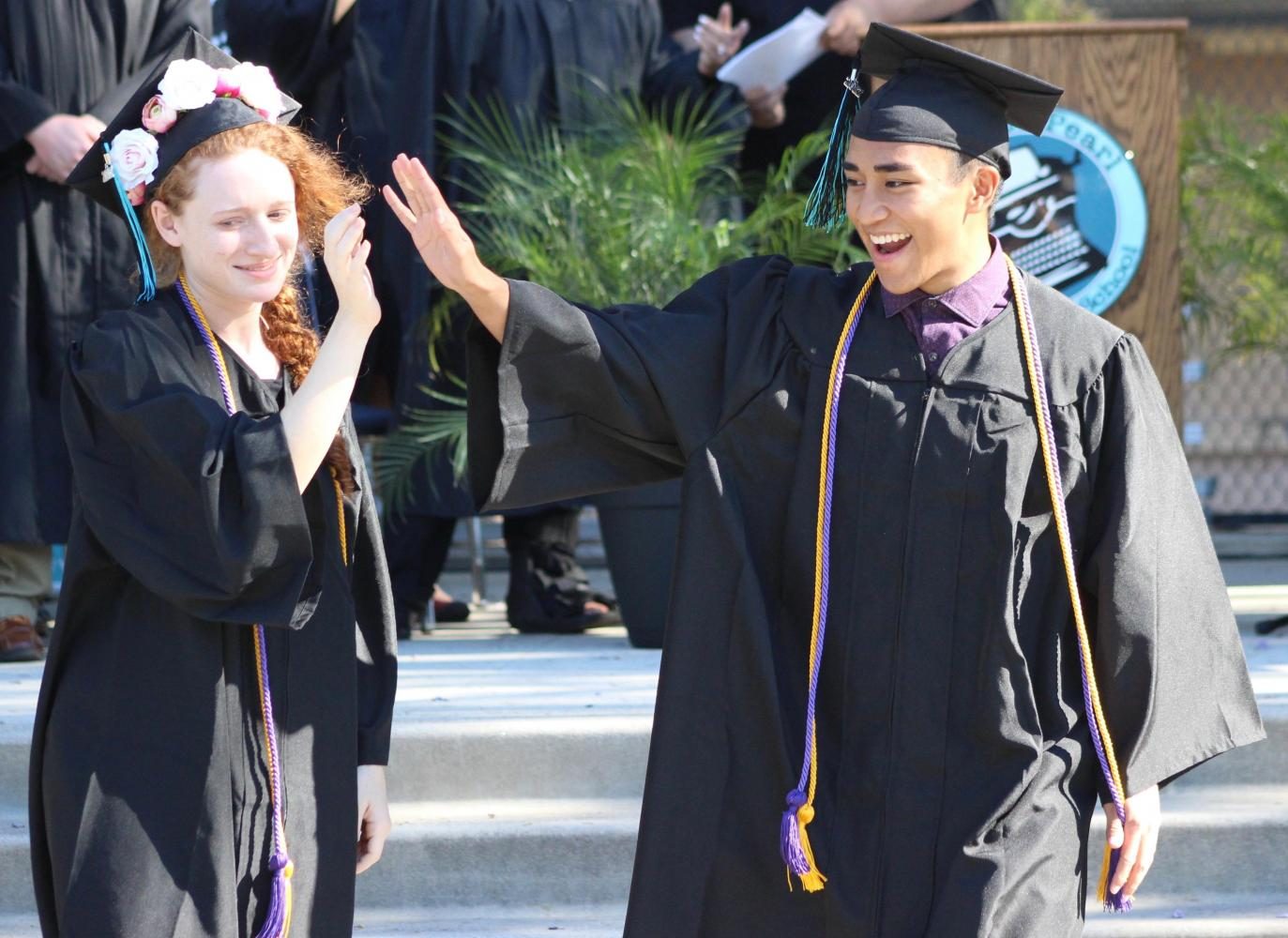 Raquel Dubin and Chester Castro congratulate each other after walking across the stage during the commencement ceremony.