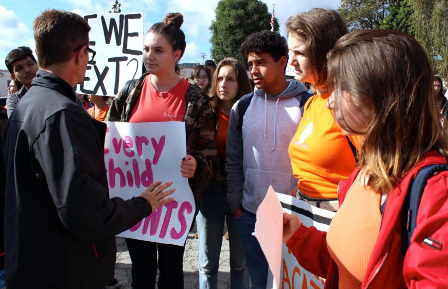  Junior Adrian Contreras, Principal Deborah Smith, senior Madison Feinstein, junior Lauryn Uhlenberg, senior Adonis Arevalo, juniors Bella Feinstein and Alexis Lucy Ishkhanian discuss where to march during the #Enough Walkout on March 14.