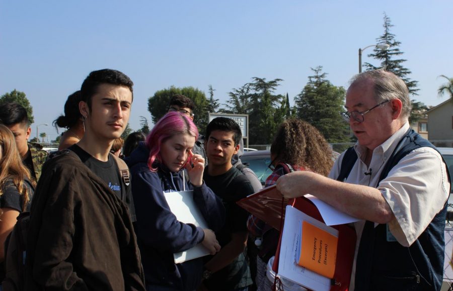 Physical sciences teacher Stephen Schaffter takes roll for his second period class during the fire drill.