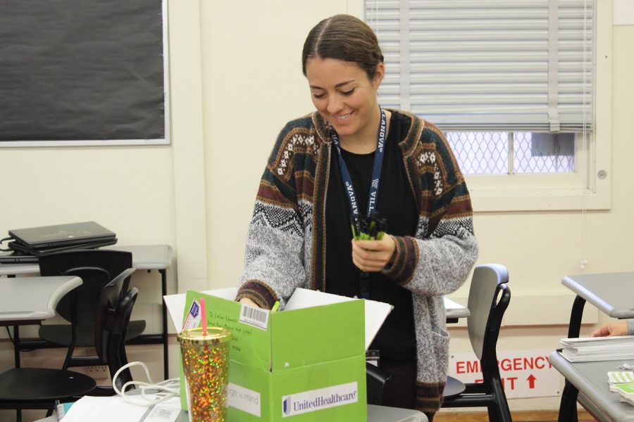 Social work intern and club sponsor Callan Edwards passes out pens to promote the club during a club meeting Dec. 5. 