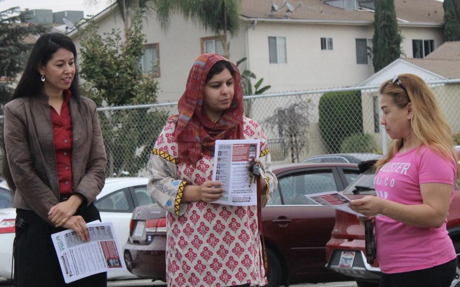 Spanish teacher Marta Rodriguez and resource teacher Sadia Aziz talk with a parent when teachers distributed fliers on union contract negotiations with the school district back in October. 