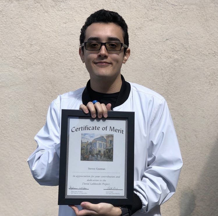 Senior+Steven+Guzman+poses+with+his+certificate+for+Outstanding+Achievement+and+Contribution+for+the+David+Labkovski+Project.+
