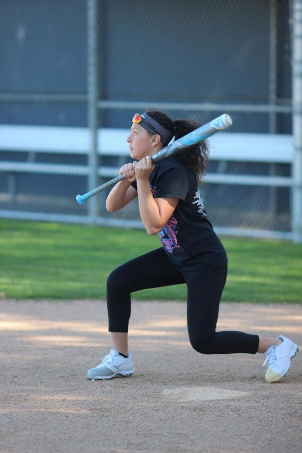 Freshman varsity player  Emily Flores prepares to bunt during practice on March 14.