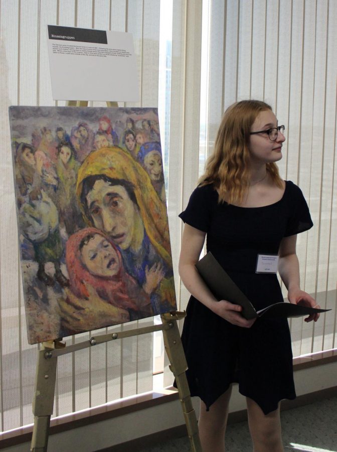 Sophomore Susannah Ness prepares to explain a painting by David Labkovski to guests.