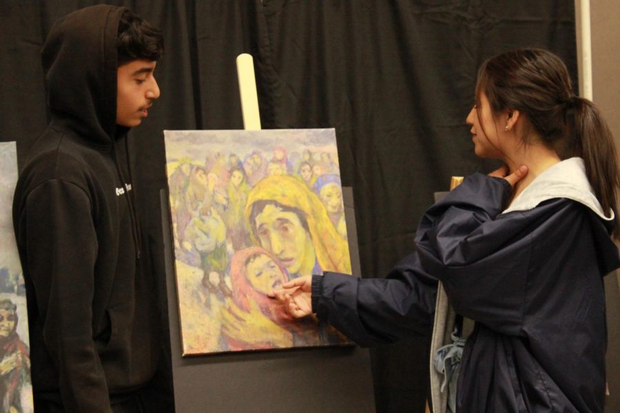 Sophomore Devin Contreras explains this David Labkovski painting to Anie Lopez on May 9.