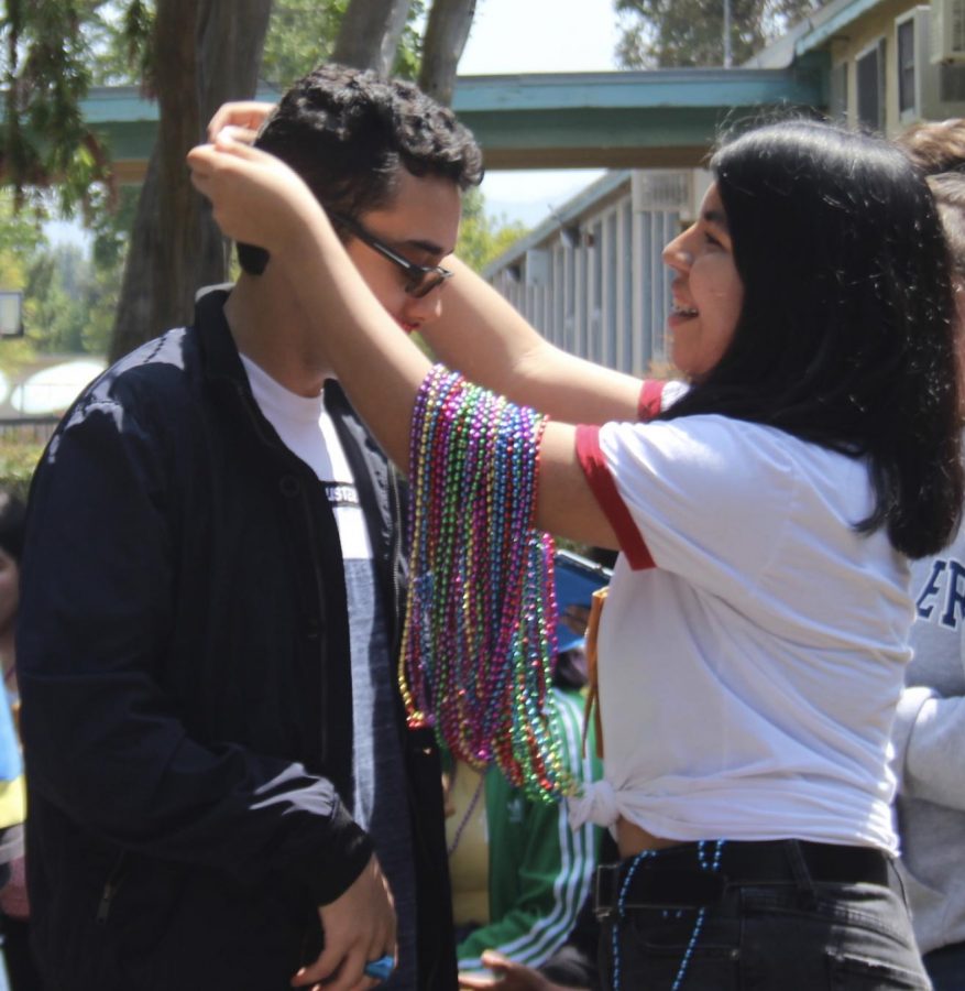 Senior Steven Guzman is given a necklace by junior Angie Rumbo on May 3. 