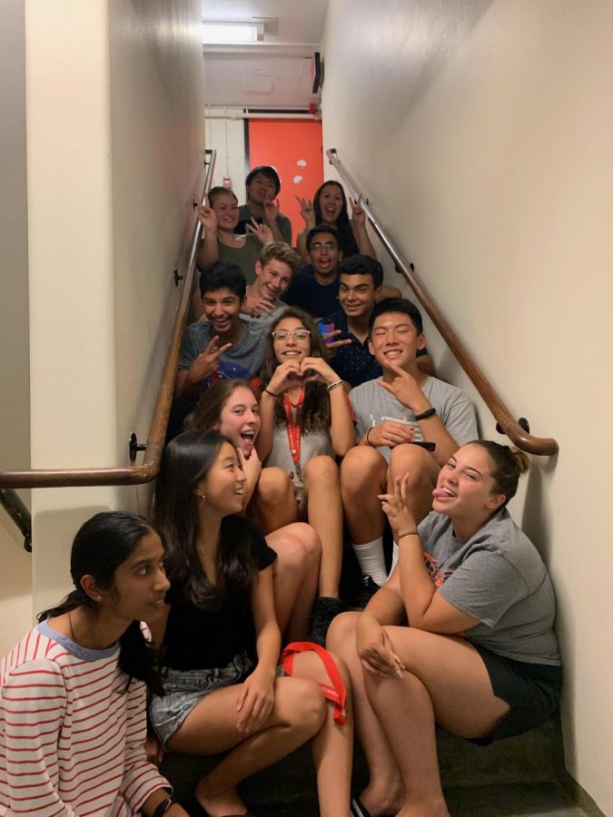 Junior Maria Strake  sits on the steps inside the Leverett House tower with her proctor group on the last day of the program. 