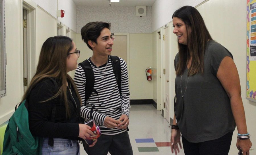 Juniors Bella Jimenez and Jair Sanchez share a smile with principal Pia Damonte during nutrition on Oct. 24.