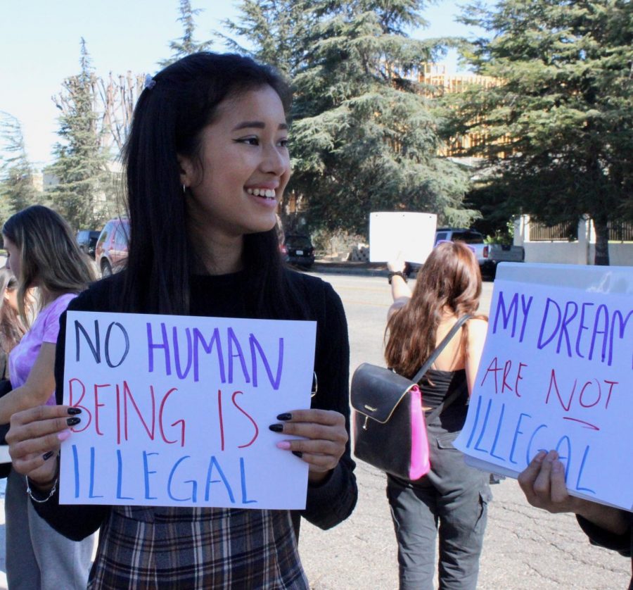 Senior Mia Garcia shares a smile with her fellow protestor after receiving a honk in support for the Deferred Action for Childhood Arrivals (DACA) protest /walkout on Nov. 12. 