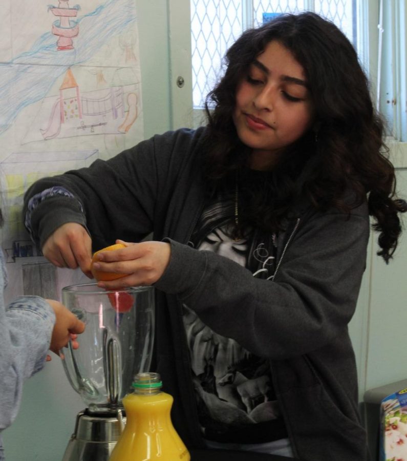 Senior Elizabeth Cortez helps to make a delicious smoothie by peeling a grapefruit into the blender in the Cooking club on Feb. 13. Cooking Club meets every Friday or Thursday during lunch to make yummy drinks and desserts in Room 19.