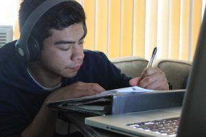 Senior Daniel Raymundo works on his assignments that were posted on Schoology for the duration schools are closed due to COVID-19. Teachers are expected to assign more work, but without their assistance, they are putting more confusion and frustration upon students.

