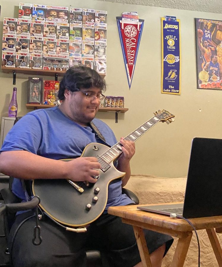 During a Zoom session with DPMHS music students, alumnus Matthew Sarenana plays his guitar. 