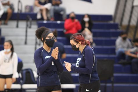 Varsity volleyball teammates Naamah Silcott and Cheyanne  Losino exchange words of encouragement during their regular season match against Cleveland Charter High School.