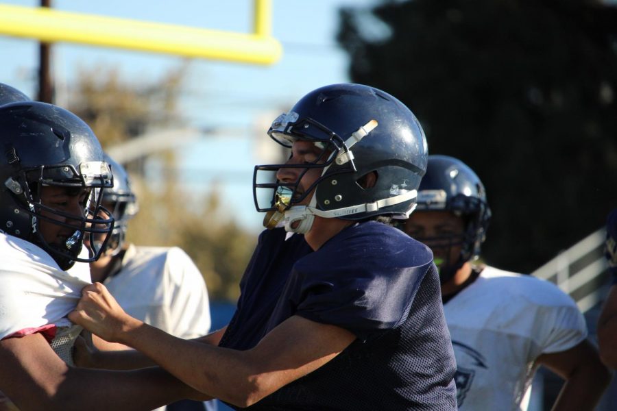 Diego Villanueva grabs  hold of an offensive linemans jersey during an intersqaud scrimmage on Oct.26.