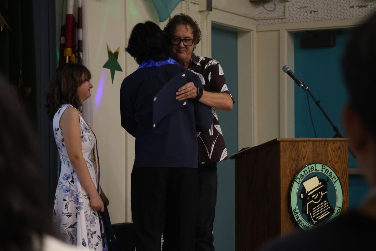 Senior Sebastian Olfatmanesh hugs Video Production teacher Tennessee Norton after being given an award during Senior Awards Night on May 28.