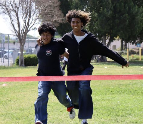 Three-legged race champions Axel Aleman and Josiah Lands leap to the finish line during the final round of the race.