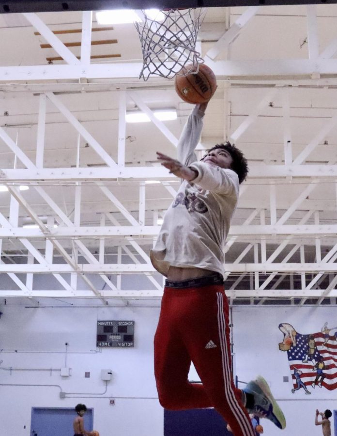 Varsity small forward Justice Harper works on his one-handed slam dunk during practice for the Birmingham Community Charter High School Patriots.