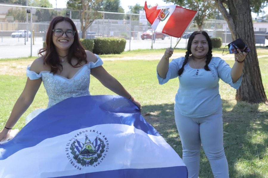 Juniors Lauren Galvez and Jenna Rodriguez pose with their flags for Hispanic Heritage month on Fiesta Friday. Students and staff were encouraged to dress in their cultural clothes. Rodriguez wore a striking blue quinceanera dress with her Salvadorian flag while Galvez waved the flag of Peru.
