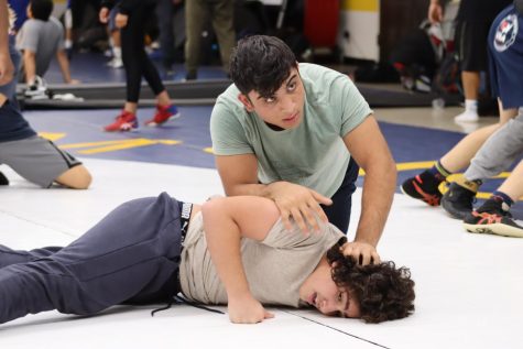 Junior Arvin Khosravy wrestles with a teammate during a warm-up at Birmingham Charter High School on Oct. 28.