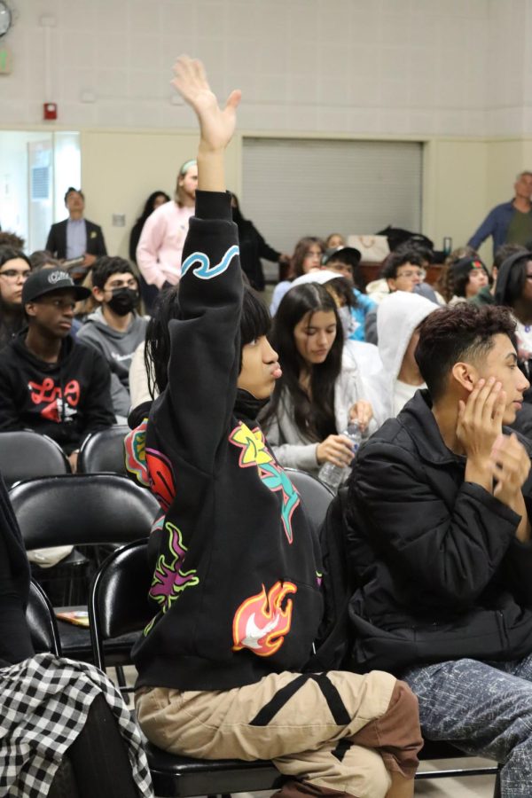 Junior Ravi Fuad raises his hand to ask a question during the fentanyl assembly on Jan. 12.