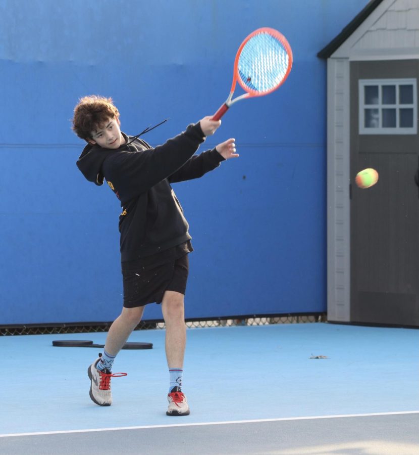 Freshman Mose Judge hits a tennis ball to warm up during boys tennis practice on Jan. 18. 