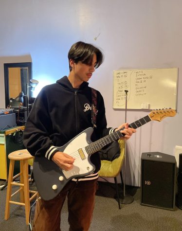 Freshman Sebastian Olfatmanesh plays a guitar in a rented music studio on March 21 to prepare for the upcoming spring concert and rescheduled open house performance.