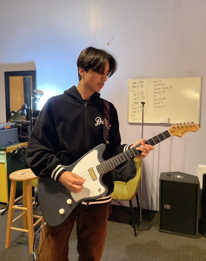 Freshman+Sebastian+Olfatmanesh+plays+a+guitar+in+a+rented+music+studio+on+March+21+to+prepare+for+the+upcoming+spring+concert+and+rescheduled+open+house+performance.