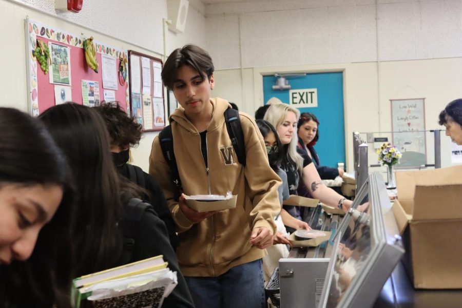 Freshman Sebastian Olfatmanesh stands in line as he picks out food from the cafeteria during lunch on March 15. Many students take the school lunch, which is free.