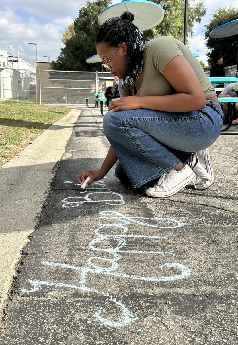 Senior Madyson Phillips writes “Happy Birthday Constitution” with chalk during the period 2 AP Government class on Sept. 18. For the activity, students drew words and pictures with chalk in observation of Constitution Day. Every year on Sept. 17, the official ratification of the Constitution in 1787 is remembered through this holiday.