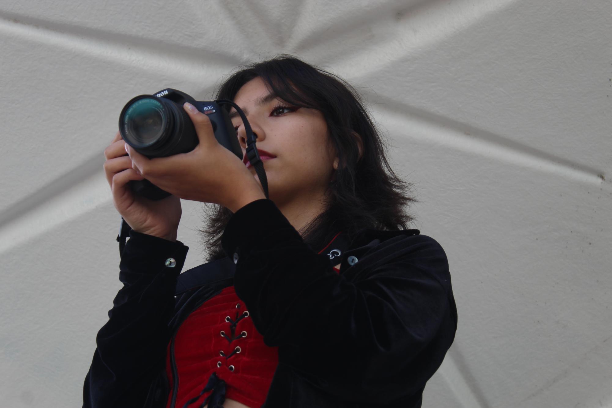 Junior Alia Galvan adjusts a camera to take a photo from overhead on Sept. 22. Photography principles like “bird’s eye view” were reviewed in the courtyard for the period 1 experimental photography class.