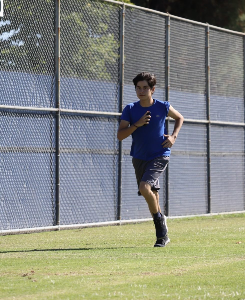 Junior Diego Vera Suarez runs warm up laps during cross country practice at Birmingham Community Charter High School on Oct. 11.