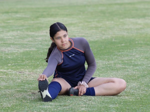 Sophomore Marianna Alvarez Patino stretches on the field before soccer practice at Birmingham Community Charter High School on Nov. 29.