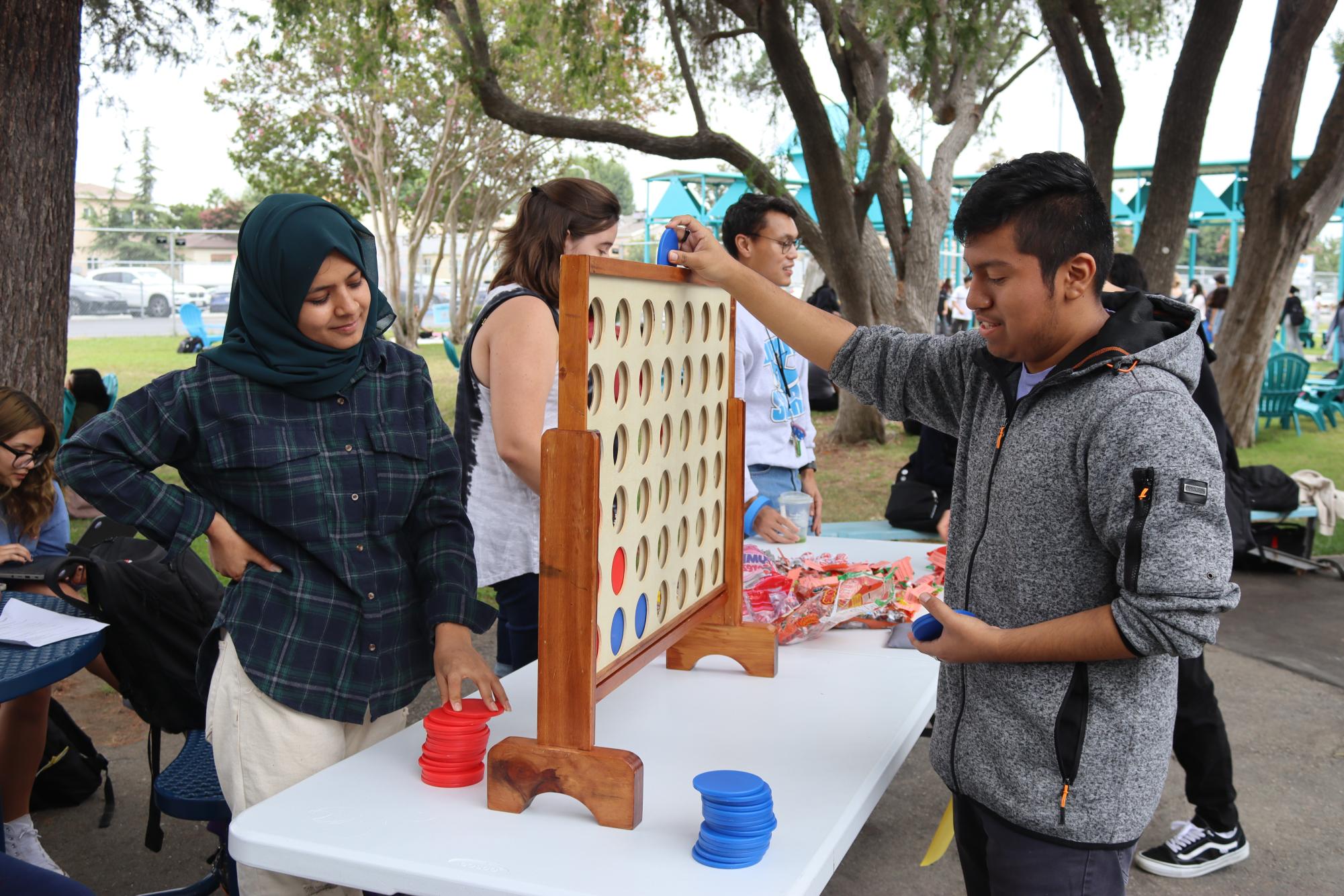 Senior Behishta Safi plays Connect 4 with senior Anthony Jimenez during Fiesta Friday in the grove on Sept. 29.