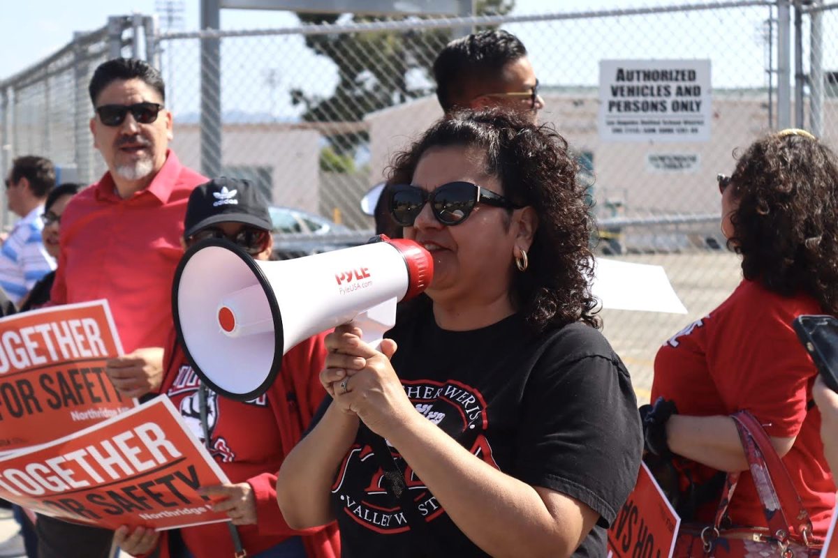 Valley West United Teachers Los Angeles (UTLA) Area Chair Wendy Lucia Lozano shouts into a megaphone to oncoming cars on Balboa Boulevard during a picket on May 16. UTLA members and families picketed to hold the district accountable for campus safety on school grounds. 